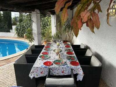 a table with plates of food on it next to a pool at Casa AncoraDouro in Lagos