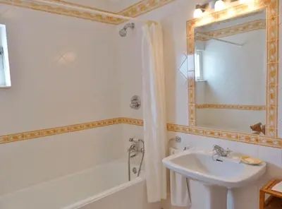 a bathroom with a sink and a tub and a mirror at Casa AncoraDouro in Lagos