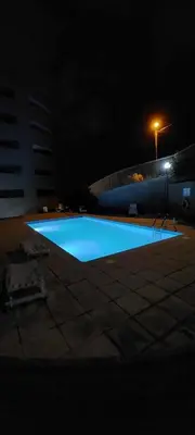 a large blue swimming pool at night with a building at GuestReady - Relax in Style in Funchal in Funchal
