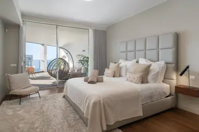 a bedroom with a large white bed and a balcony at OurMadeira - Palace Ocean View in Funchal