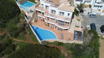 a swimming pool with a view of the ocean at Simply Salema - Casa das Estevas - Beach Villa in Salema