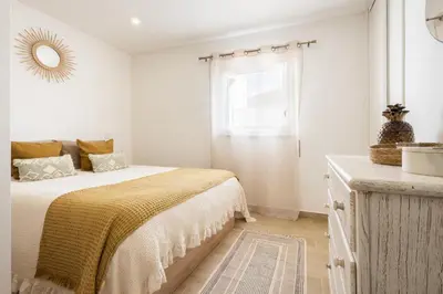 a white bedroom with a bed and a window at CASA Castelejo in Vila do Bispo