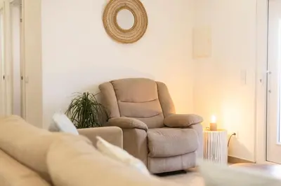 a living room with a chair and a mirror at CASA Castelejo in Vila do Bispo