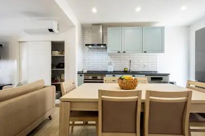 a kitchen with a wooden table with chairs and a bowl of fruit at CASA Castelejo in Vila do Bispo