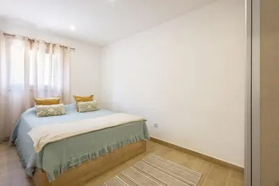 a small bedroom with a bed and a window at CASA Castelejo in Vila do Bispo