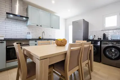 a kitchen with a wooden table with chairs and a sink at CASA Castelejo in Vila do Bispo