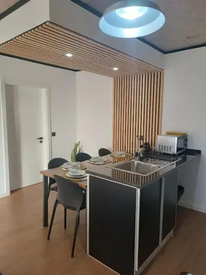 a kitchen with a sink and a table with chairs at Kings B&B Eiras in Caniço