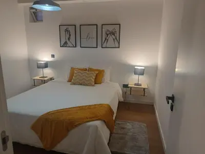 a bedroom with a white bed and two lamps at Kings B&B Eiras in Caniço