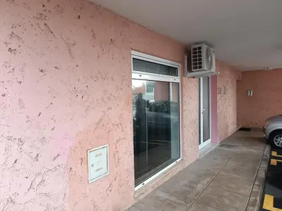 a pink wall with a window in a parking lot at Kings B&B Eiras in Caniço