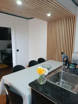 a kitchen with a sink and a table with flowers on a counter at Kings B&B Eiras in Caniço