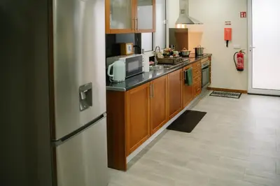 a kitchen with wooden cabinets and a refrigerator at Casa do Remo in Caniçal