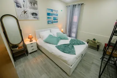 a small bedroom with a bed and a mirror at Casa do Remo in Caniçal