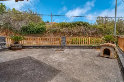 a backyard with a fence and a dog house at Casa Levada dos Prazeres by Stay in Prazeres