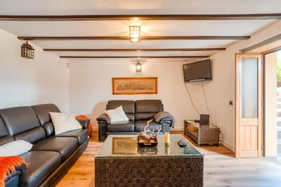 a living room with leather furniture and a flat screen tv at Casa Levada dos Prazeres by Stay in Prazeres