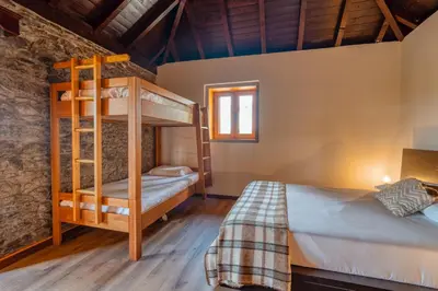 a bedroom with two bunk beds and a window at Casa Levada dos Prazeres by Stay in Prazeres