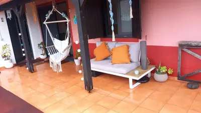 a porch with a swing and a hammock at Quinta Vista para o Pico in Faial
