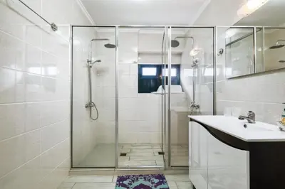 a bathroom with a glass shower and a sink at Casa da Avó Paraíso 1 in Machico