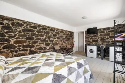 a bedroom with a stone wall with a bed at Casa da Avó Paraíso 1 in Machico