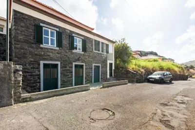 a house with a car parked in front of it at Casa da Avó Paraíso 1 in Machico