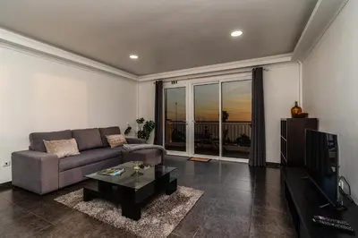 a living room with a couch and a tv at Casa Branca, in the Heart of Arco da Calheta in Arco da Calheta