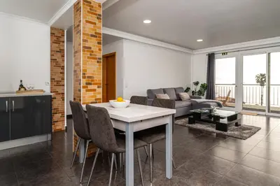 a kitchen and living room with a table and chairs at Casa Branca, in the Heart of Arco da Calheta in Arco da Calheta