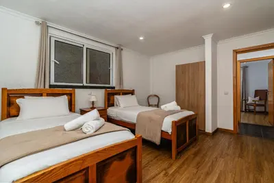 a bedroom with two beds and a window at Casa Branca, in the Heart of Arco da Calheta in Arco da Calheta