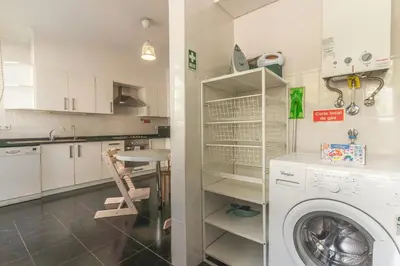 a kitchen with a washing machine and a table at Quintas Village AY by Atlantic Holiday in Caniço