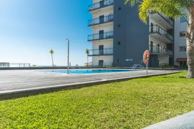 a swimming pool in front of a building at Quintas Village AY by Atlantic Holiday in Caniço