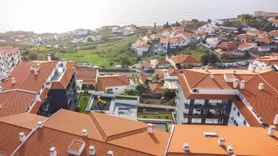 an aerial view of a town with houses and the ocean at Quintas Village AY by Atlantic Holiday in Caniço