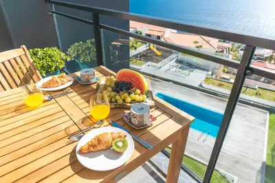 a table with a plate of food and glasses of orange juice at Quintas Village AY by Atlantic Holiday in Caniço