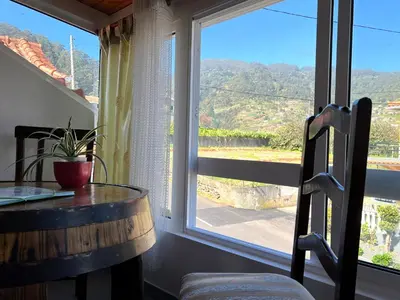 a bathroom with a sink and a mirror and towels at Sea & Mountain View Lombo de Cima House BBQ & Wifi in Santana