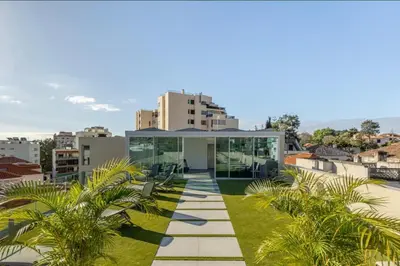a glass house on a roof with palm trees at Infinity Haven in Funchal