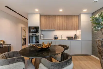 a kitchen with white cabinets and a table and chairs at Infinity Haven in Funchal