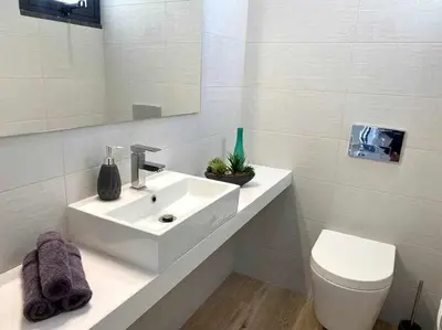 a white bathroom with a sink and a toilet at Shangri Sol - Holiday house in Arco da Calheta
