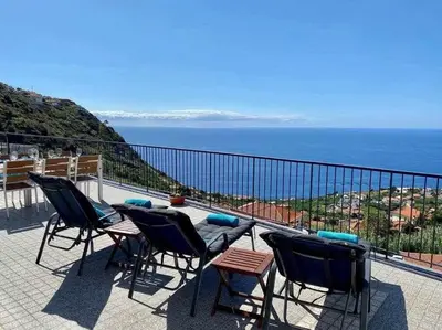 a balcony with chairs and a view of the ocean at Shangri Sol - Holiday house in Arco da Calheta