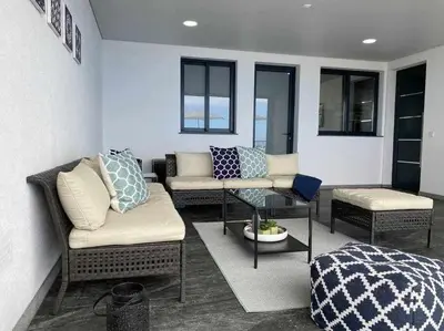 a living room with couches and a bed and windows at Shangri Sol - Holiday house in Arco da Calheta