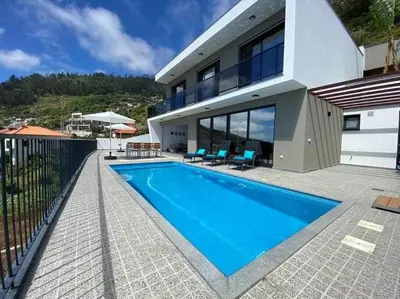 a house with a swimming pool in front of it at Shangri Sol - Holiday house in Arco da Calheta