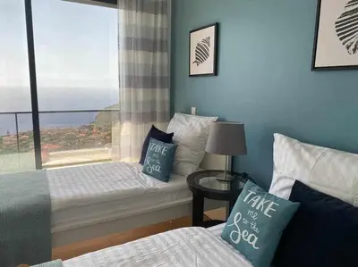 a bedroom with a bed and a window with a view at Shangri Sol - Holiday house in Arco da Calheta