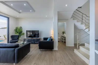 a living room with a couch and a staircase at Ocean and Palms in Arco da Calheta