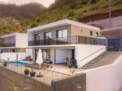 a house on a hill with a swimming pool at Ocean and Palms in Arco da Calheta