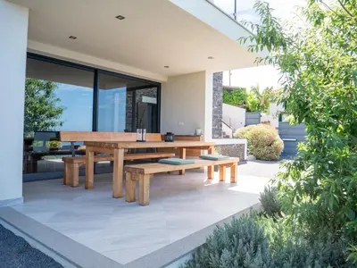 an outdoor dining area with a wooden table and benches at Ocean's 13 in Ponta do Sol