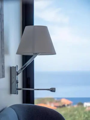 a lamp sitting next to a couch with a window at Ocean's 13 in Ponta do Sol