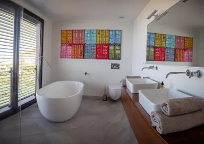a bathroom with a tub and two sinks and stained glass windows at Ocean's 13 in Ponta do Sol