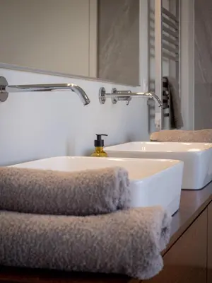 a bathroom with two sinks and a mirror and towels at Ocean's 13 in Ponta do Sol
