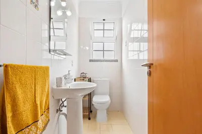 a white bathroom with a sink and a toilet at Avista Navios Holiday Home - Sea View & Free Parking in Funchal in Funchal
