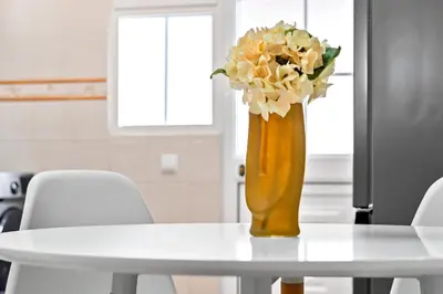 a vase filled with flowers sitting on top of a table at Avista Navios Holiday Home - Sea View & Free Parking in Funchal in Funchal