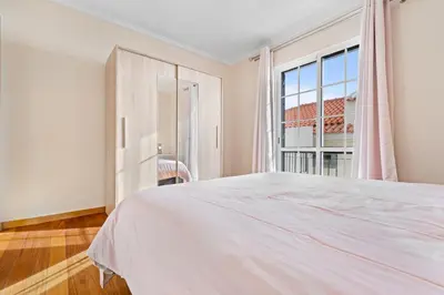 a bedroom with a large white bed and a window at Avista Navios Holiday Home - Sea View & Free Parking in Funchal in Funchal
