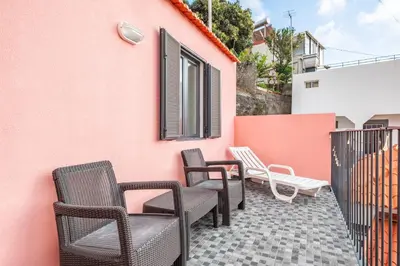 a group of chairs sitting on the side of a building at Seaside Charm II in Câmara de Lobos