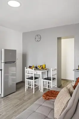 a kitchen and dining room with a table and a refrigerator at Seaside Charm II in Câmara de Lobos