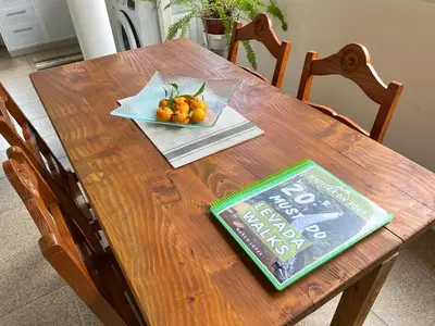 a wooden table with a bowl of oranges on it at Green Valley Cruzinhas House with Fireplace & BBQ in Santana